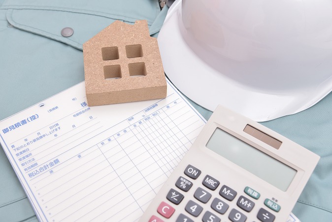 作業着とヘルメットと見積書と電卓